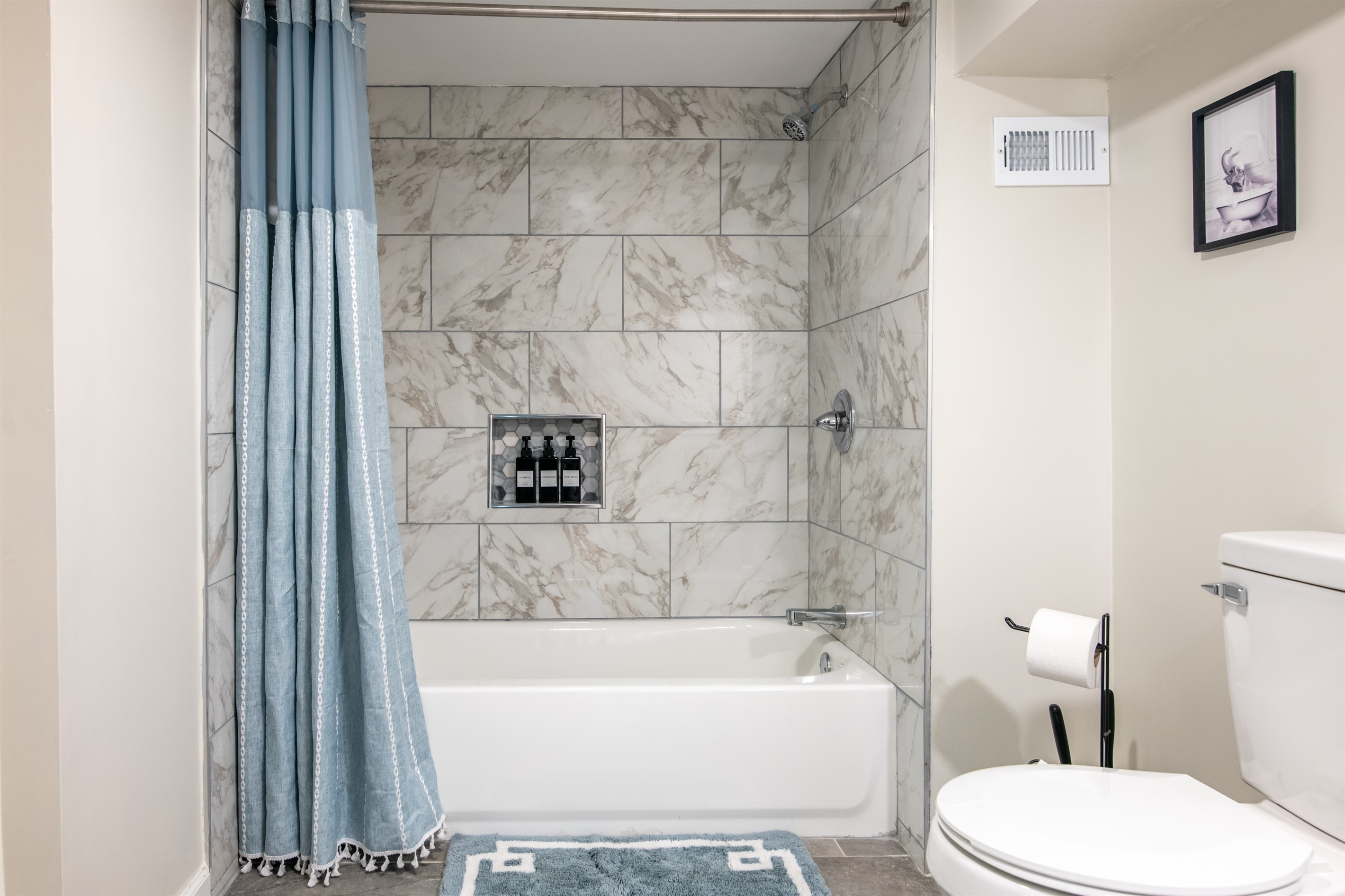 Bright and beautifully tiled bathroom with everything you need to start and end your day comfortably.