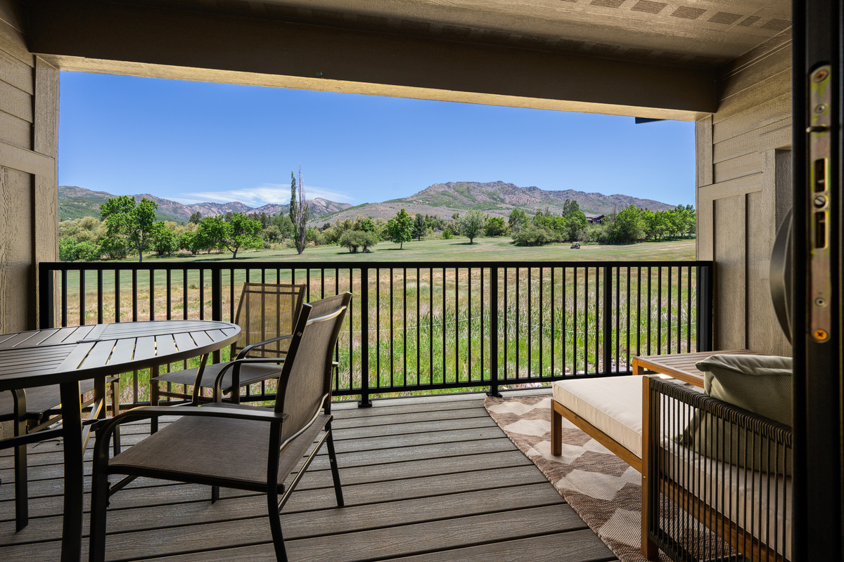 Covered balcony with panoramic golf course and mountain views.