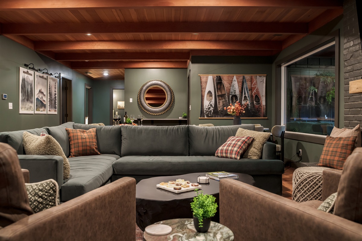 A spacious, stylish living room designed for unwinding together, with plush seating, warm textures, and room for the whole group to relax in comfort.