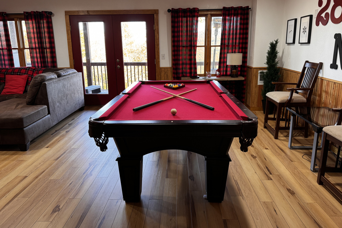 The pool table anchors the game room, with seating and deck access just steps away.