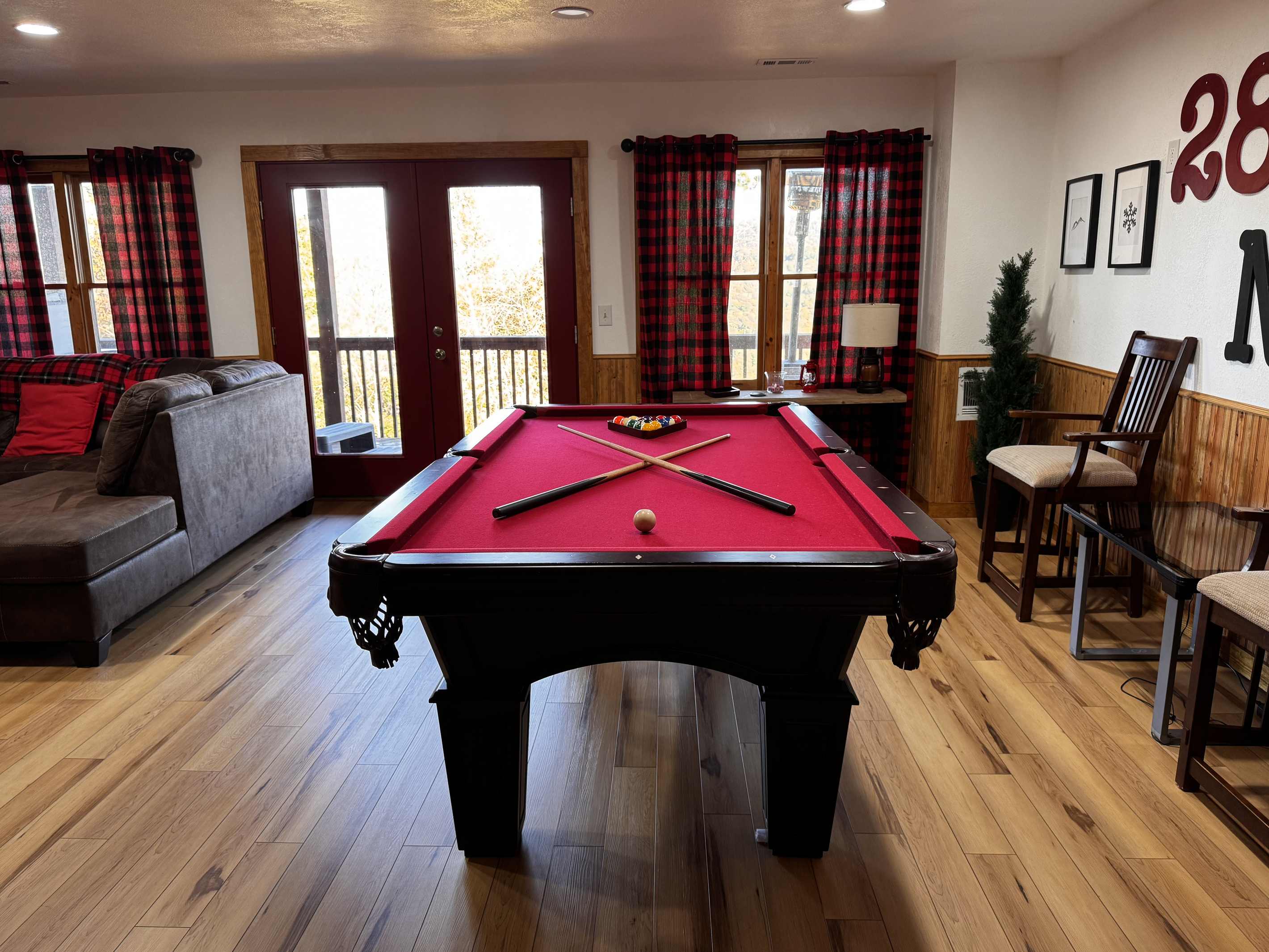 The pool table anchors the game room, with seating and deck access just steps away.