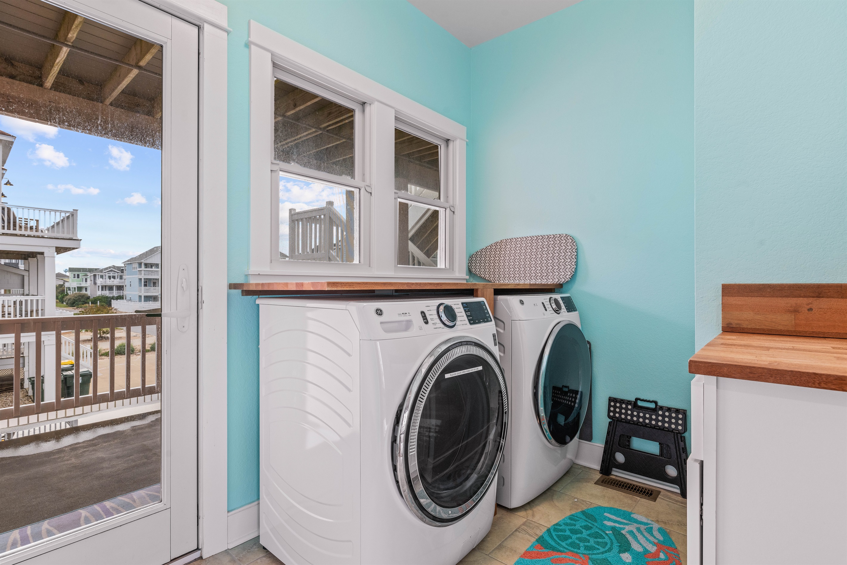 Laundry room on 2nd floor with deck overlooking backyard and access to stairs to 3rd floor and ground floor.