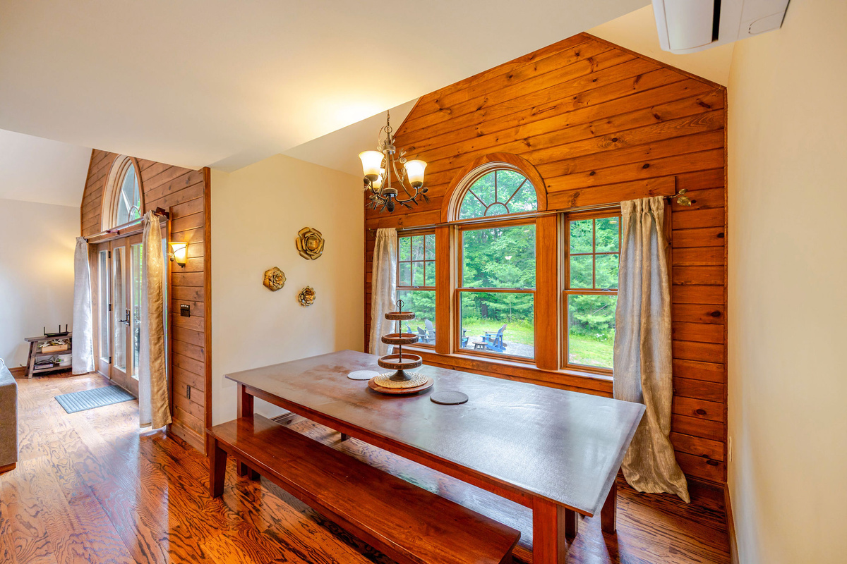 Gather around the handcrafted dining table for memorable meals while enjoying beautiful woodland views through oversized windows filled with natural light.