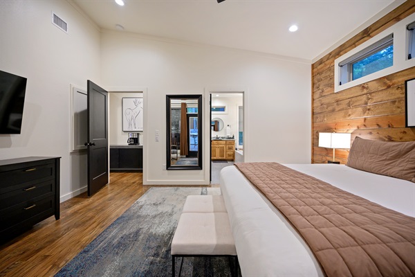 “Spacious master suite with cozy wood accents and ensuite spa bath — your peaceful retreat in the pines.”