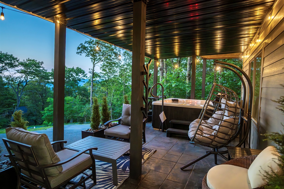 Mountain evenings call for a bubbling hot tub, a cedar sauna, and a covered patio surrounded by private trees and string lighting