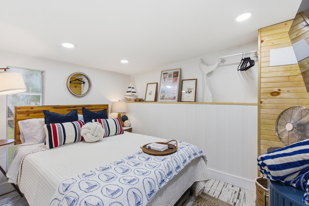 Bedroom 3 wraps you in sailboat prints, a rope knot pillow, and shiplap charm.
