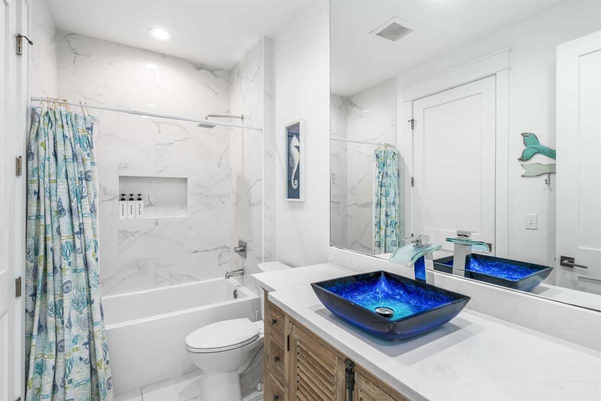 Experience coastal elegance in our second bath! ✨ Featuring a stunning blue artisan sink and bespoke louvered cabinets with 18th-century style antique brass pulls. A bright, airy space that blends high-end 30A design with timeless historic charm. 