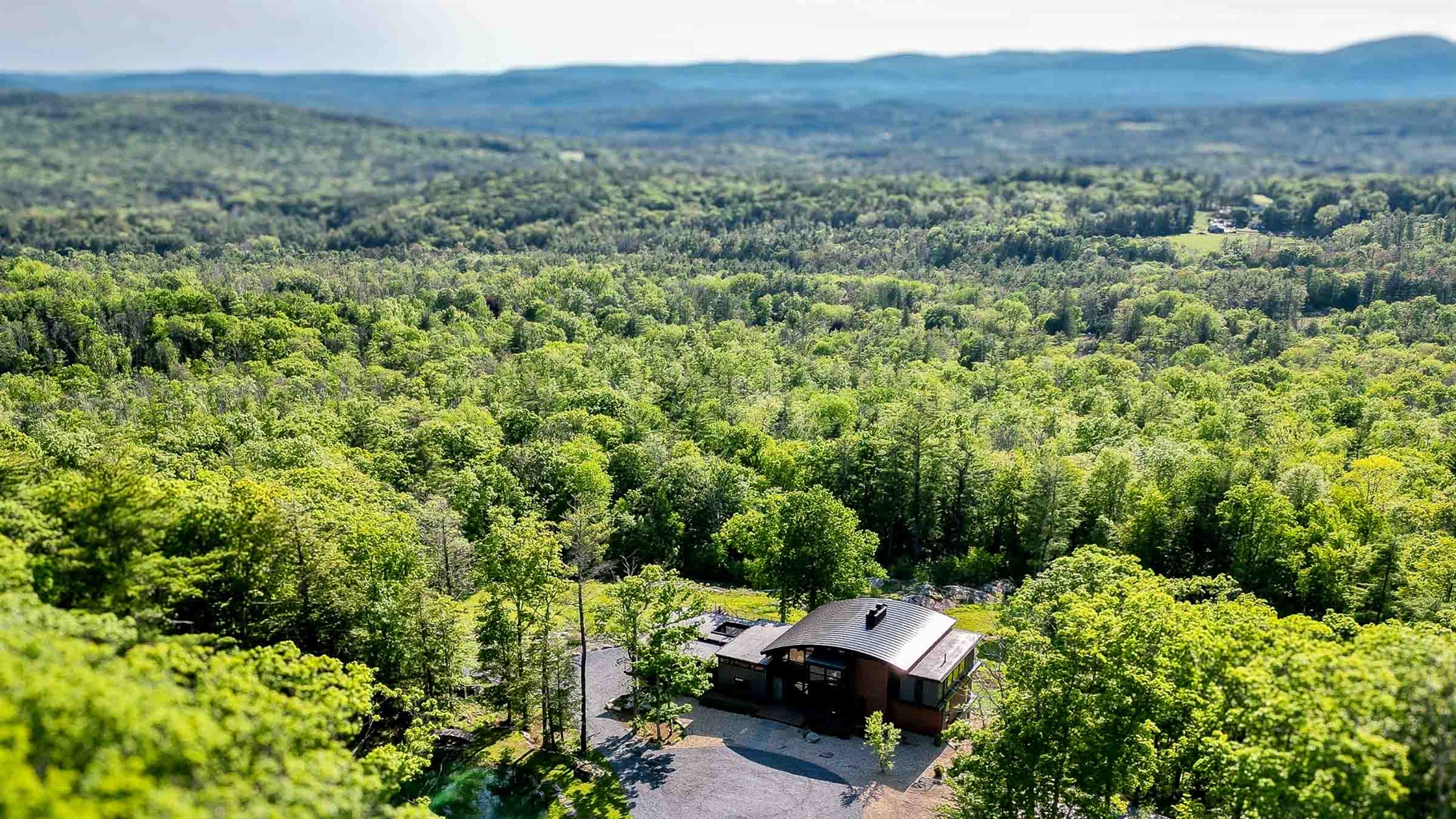 Aerial view of Sunset Falls private estate set in the green Berkshires forest with ridgeline horizon &mdash; 167 acres New Marlborough