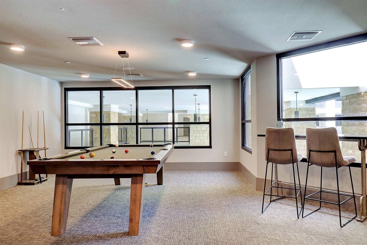 - Enjoy a modern game room with a sleek pool table and comfortable seating   - Floor-to-ceiling windows bring in natural light and relaxing views   - Perfect for friendly games and fun evenings during your stay
