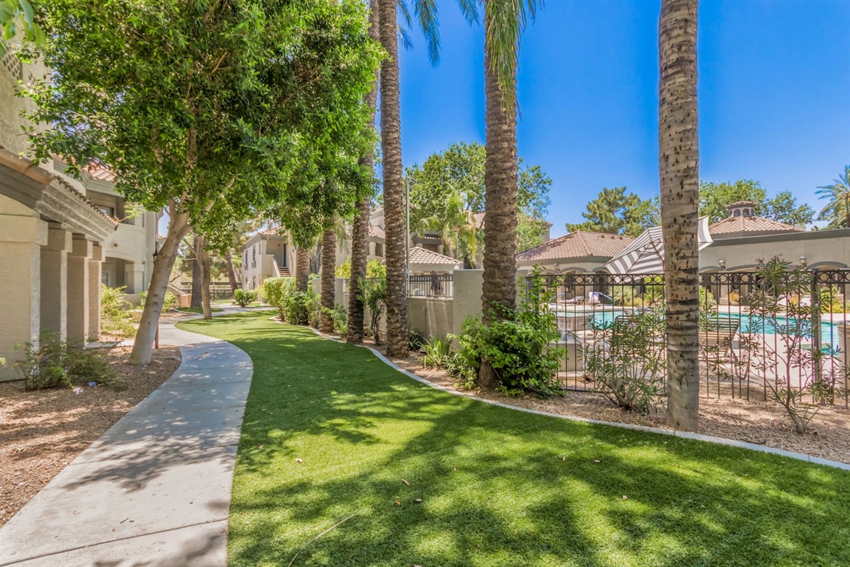 Community exterior with walking paths, green space, and easy access to the shared pool.
