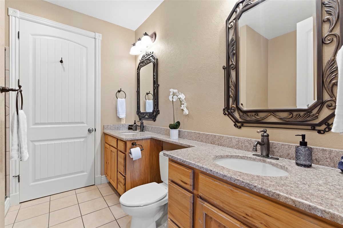 Well-designed bathroom with double vanity and granite counters.