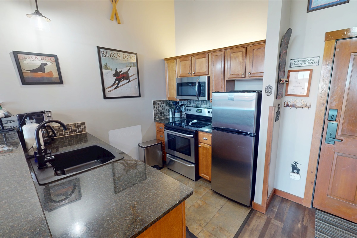 Full kitchen setup with coffee maker, oven, microwave, and breakfast bar seating.