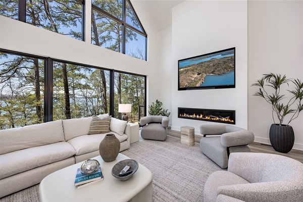 Vaulted ceilings, a wall of windows, and a fireplace make this the heart of the home—perfect for gathering, relaxing, and taking in lake views.