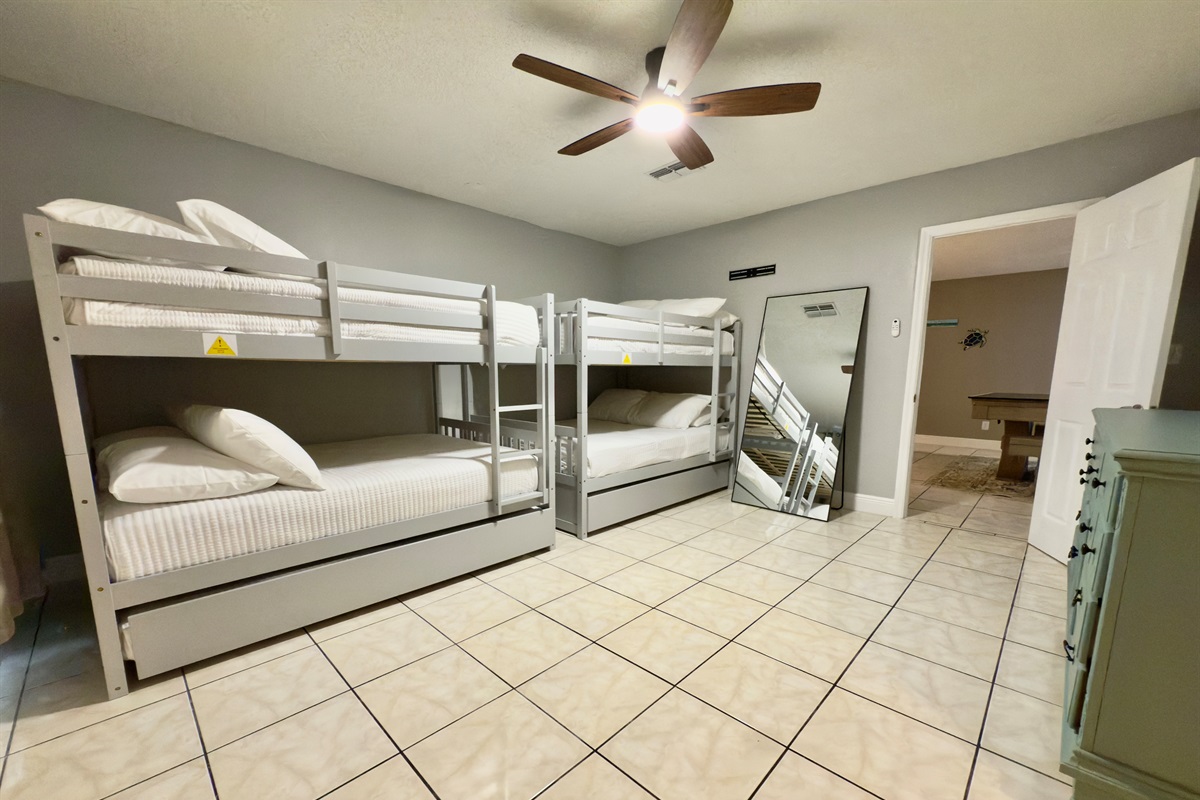Featuring two sets of sleek modern gray bunk beds with full over full and twin trundles configurations.