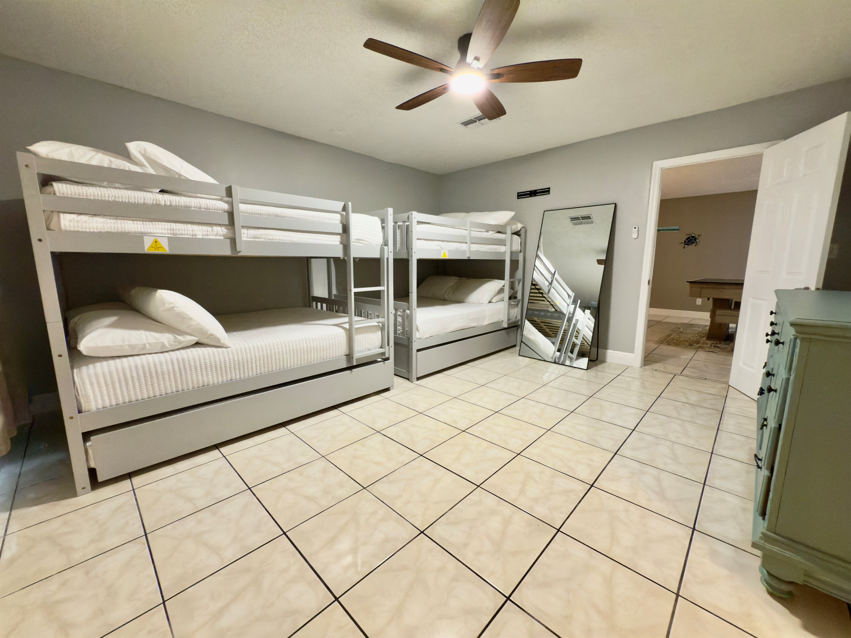 Featuring two sets of sleek modern gray bunk beds with full over full and twin trundles configurations.