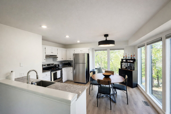 A spacious kitchen with a stainless fridge and an easy flow into the dining area.
