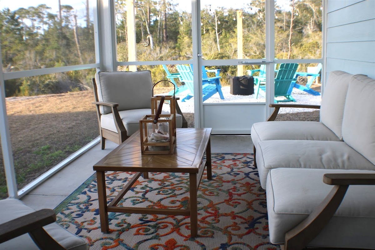 Screened-in back porch with outdoor seating—enjoy evenings bug-free.