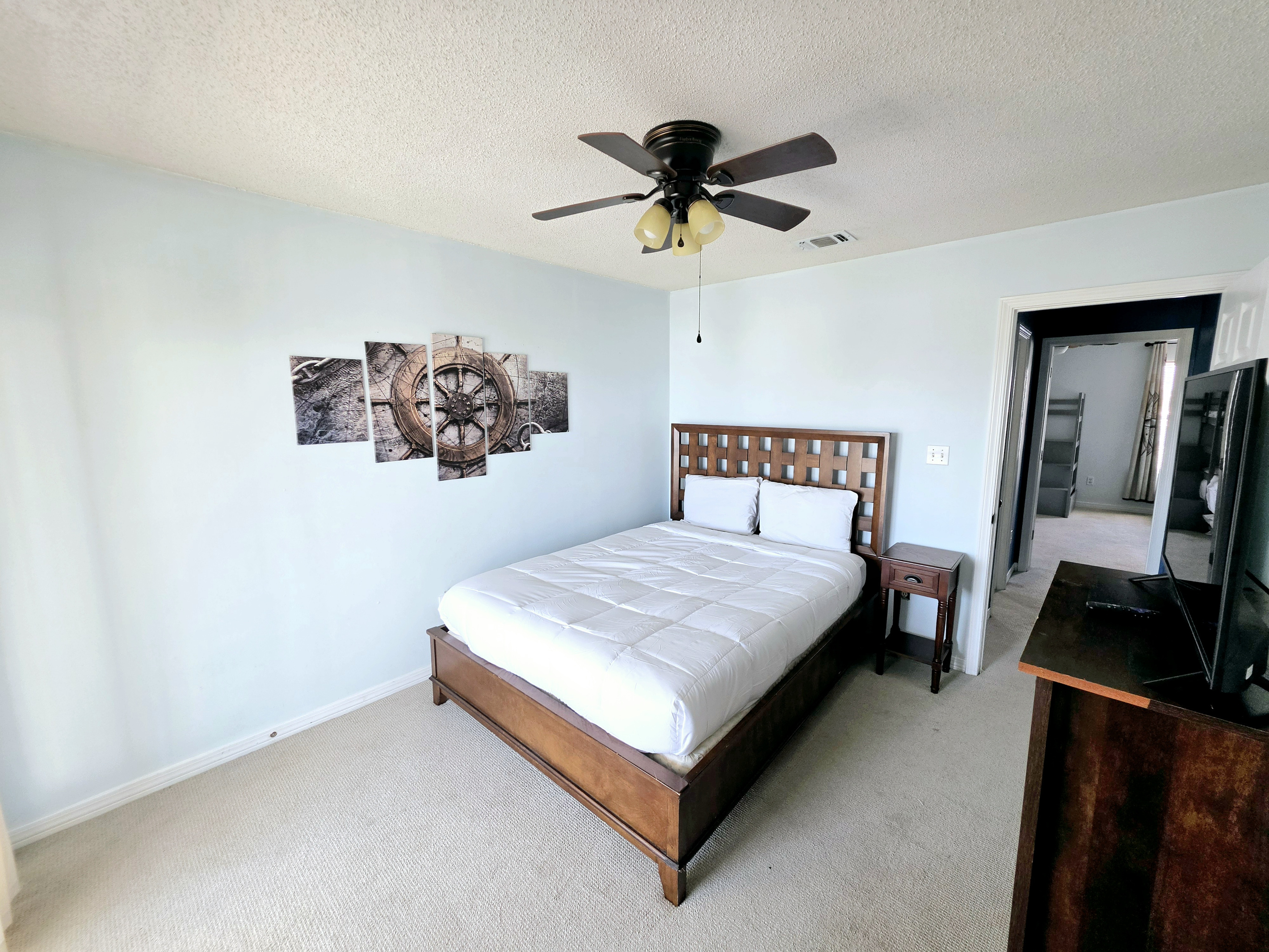 Nest side – Bedroom 2: queen bed with ship's-wheel wall art