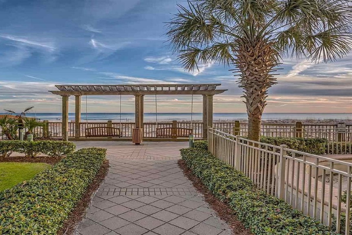 The charming pergola with its comfortable swings perfectly frames the captivating ocean view, creating an inviting and sophisticated atmosphere.