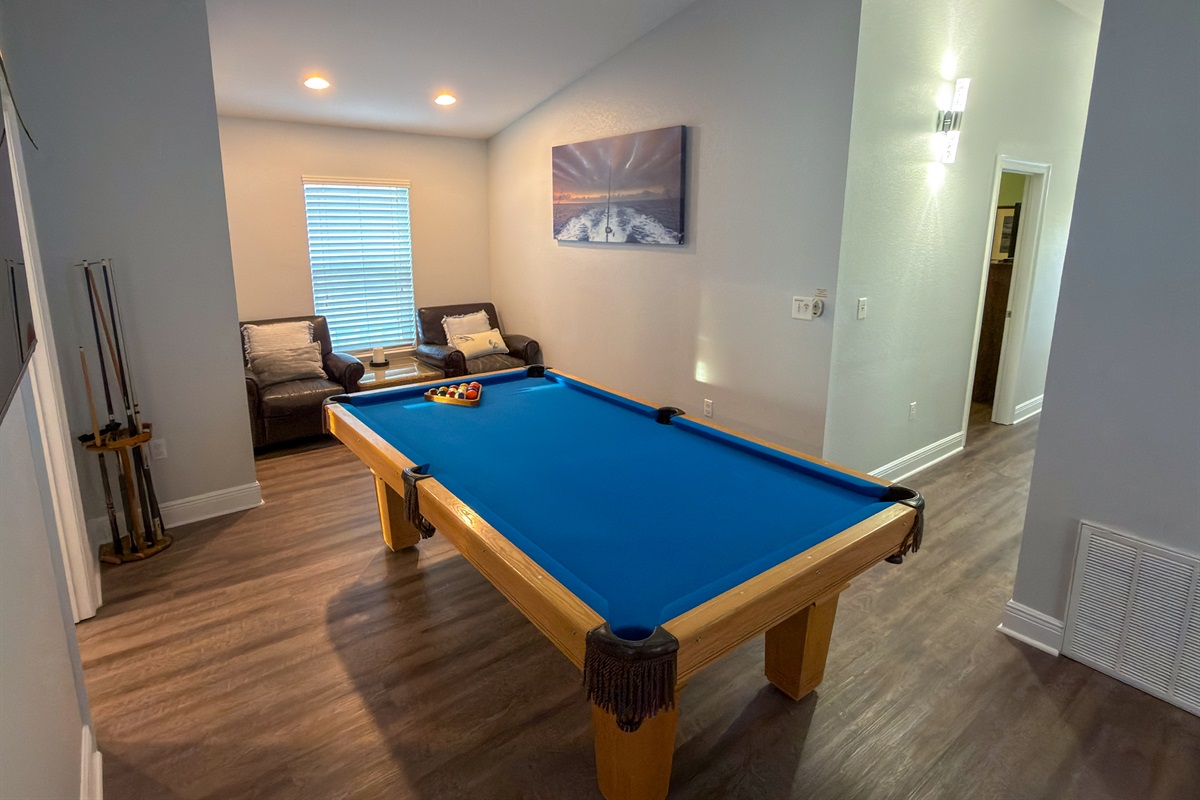 This upstairs lounge combines classic game-room fun with a cozy seating nook, ideal for watching the action or taking a quiet break.