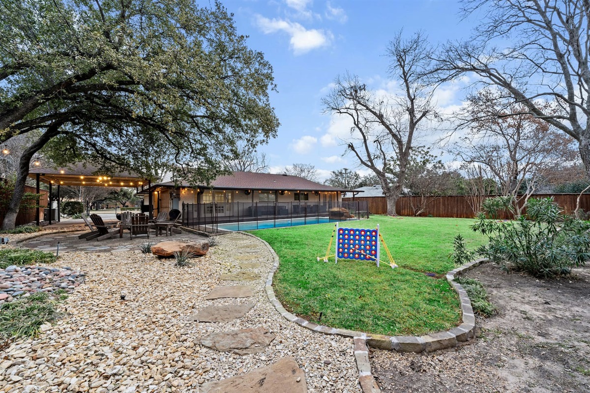 Enjoy a round of life-sized connect 4 or a game of cricket in this beautiful, spacious, private backyard adorned with plenty of mature trees and a gravel walkway.