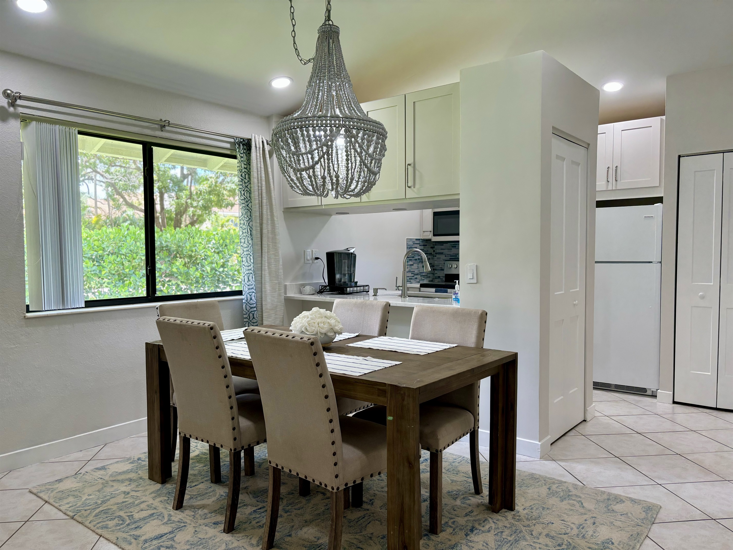The dining area is right off the kitchen with seating for five, with a convenient bar area located by the window.