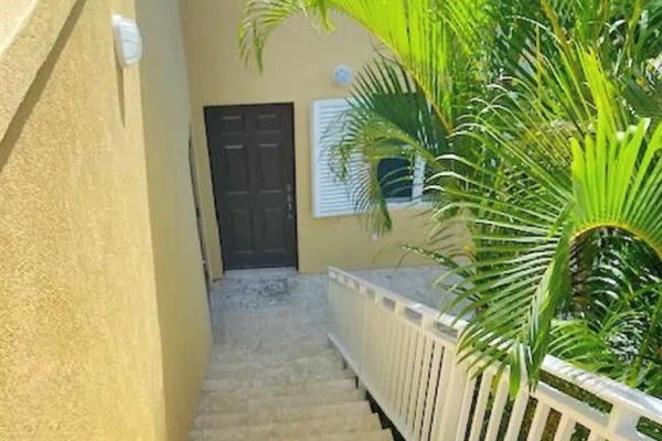 Easy-access entry with wide steps and tropical landscaping—private and peaceful fifth bedroom