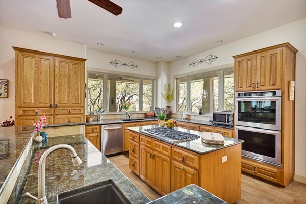 Fully equipped kitchen with island cooktop, double ovens, generous counter space, and everything guests need for easy meals during their Lago Vista stay.