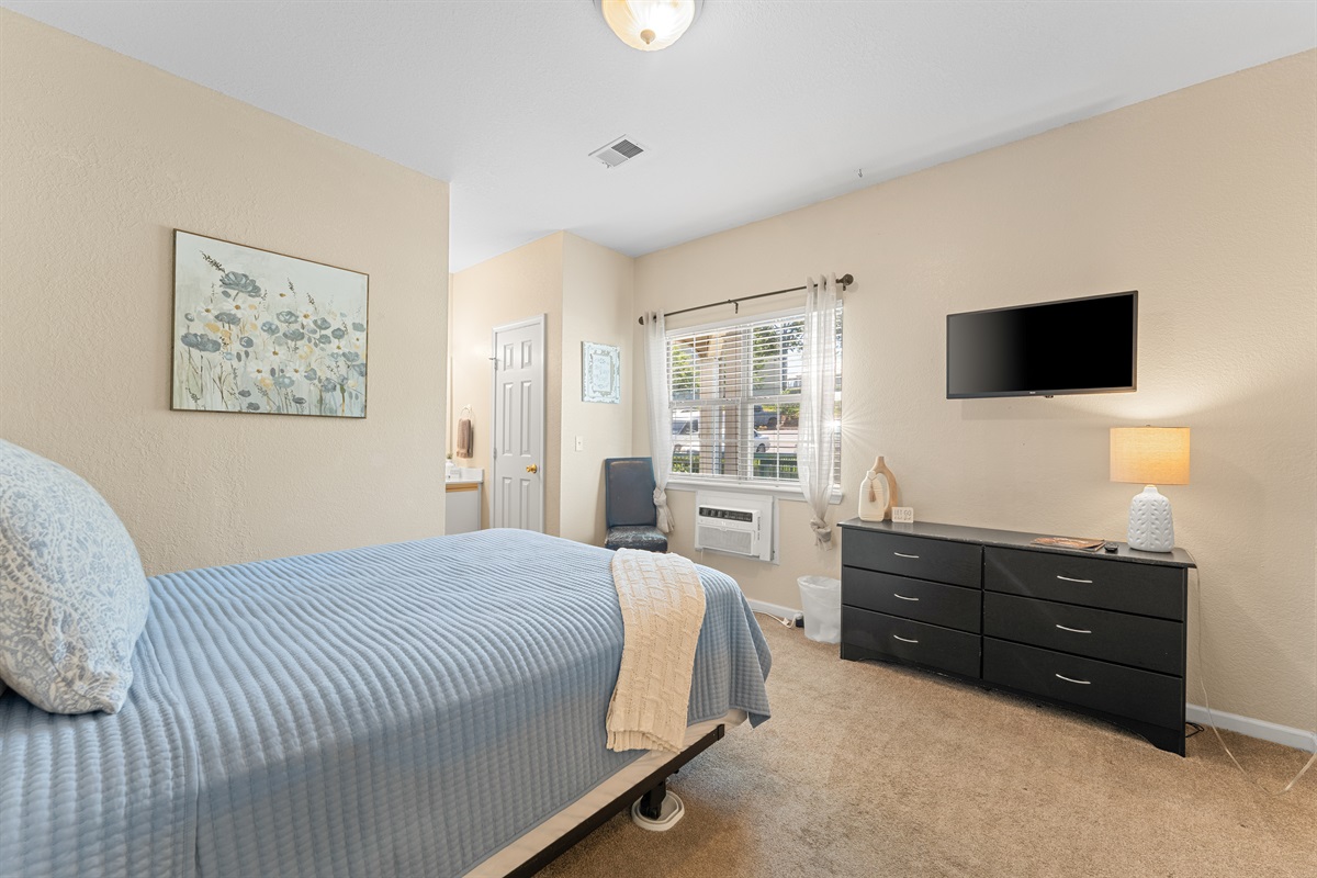 Second queen bedroom with dresser and TV gives guests a comfortable retreat of their own.