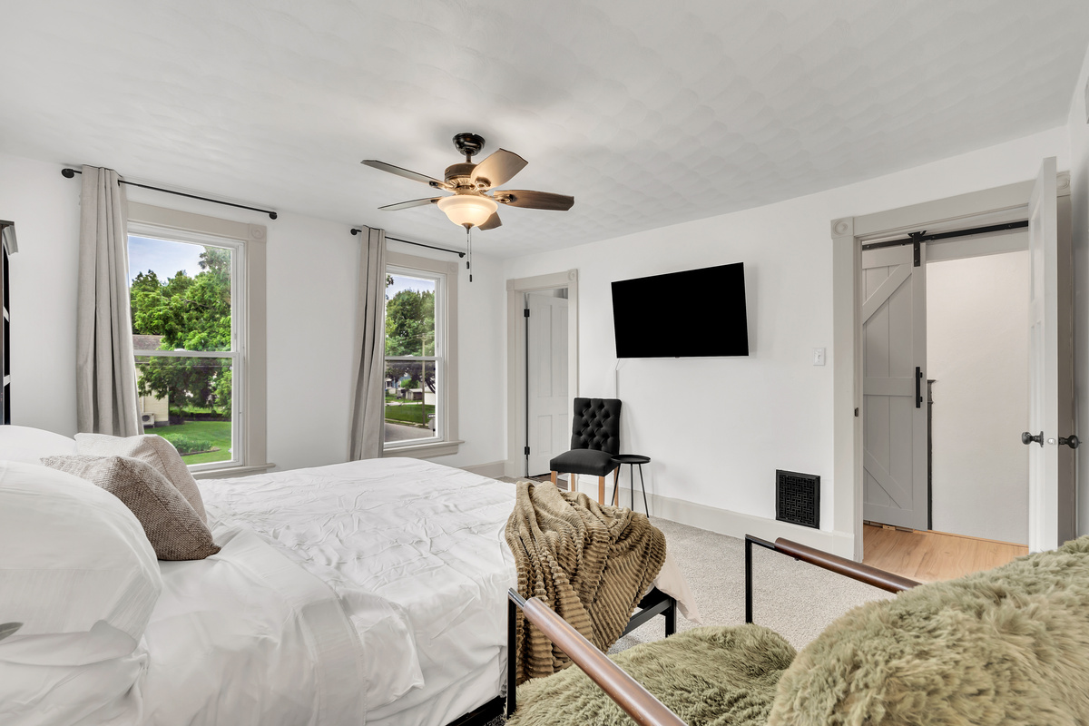 King room with extra seating, books, smart streaming tv and walk-in closet. 