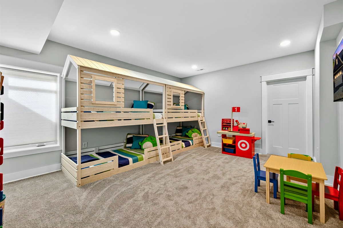 This charming quad bunk room features, crisp white bunks with bright colorful quilts, a play kitchen, Legos, books and toys make it a kids paradise! A built-in play-house coming Winter 2025 will add even more fun to this cheerful imaginative retreat.