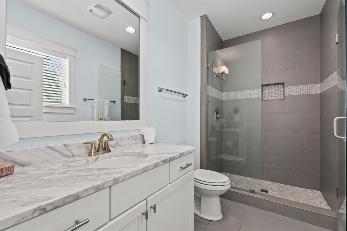 The secondary upstairs master bathroom includes a spacious walk in shower.