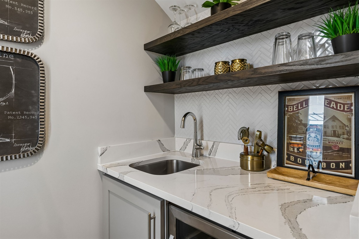 Stock the rooftop wet bar and you won't need to go back downstairs &mdash; quartz counter, glassware ready, beverage fridge stocked, and the skyline waiting.