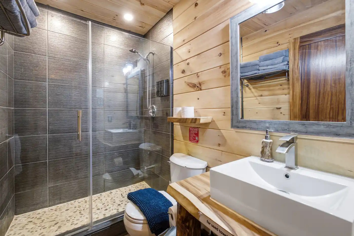Bathroom with glass shower, vanity and practical storage
