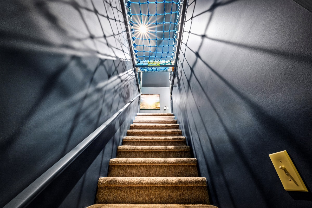 Climb up toward the stars—literally. This stairwell leads you to the whimsical 3rd floor bunk room, with a peek at the hammock net above and a promise of adventure ahead.