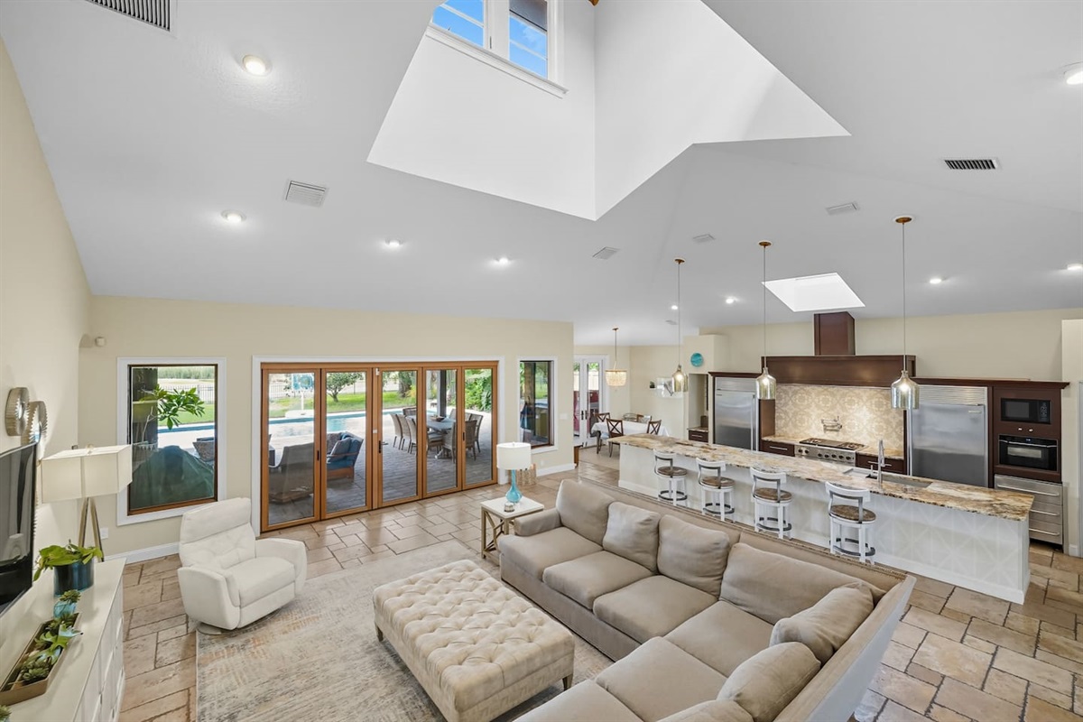 Bright living room with skylights, big sectional, Roku TV, and pool/golf views.