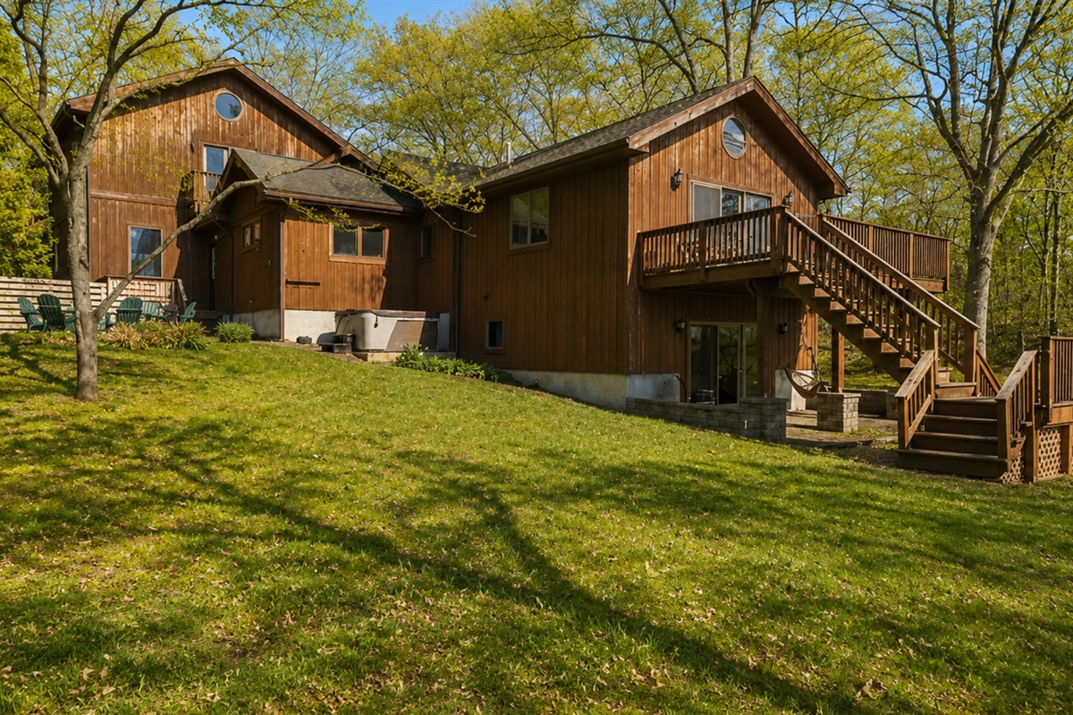 Fire Pit / Hot Tub (alongside the main house) - This spacious cabin offers a blend of comfort and nature, featuring multiple balconies and expansive green spaces, perfect for family gatherings or a tranquil retreat. 