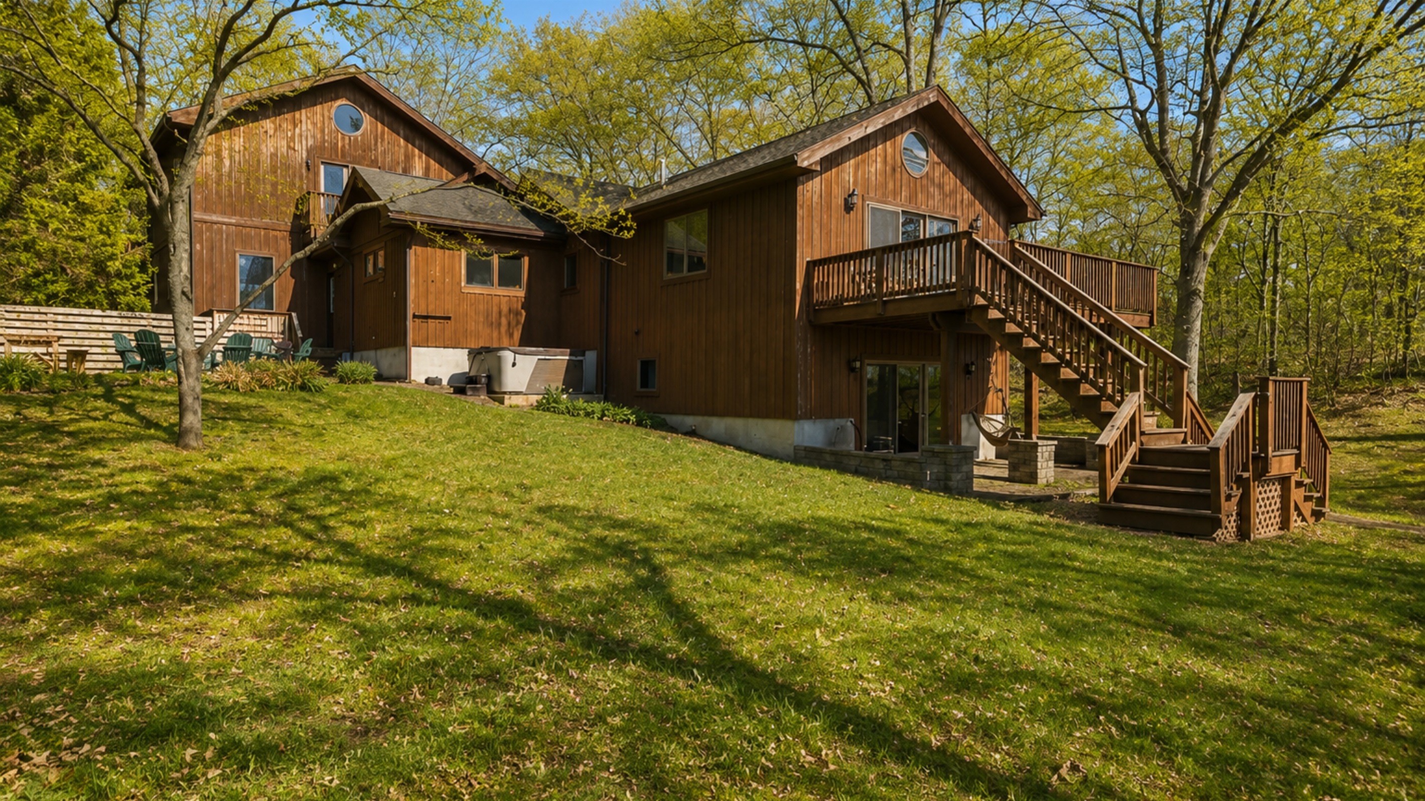 Fire Pit / Hot Tub (alongside the main house) - This spacious cabin offers a blend of comfort and nature, featuring multiple balconies and expansive green spaces, perfect for family gatherings or a tranquil retreat. 