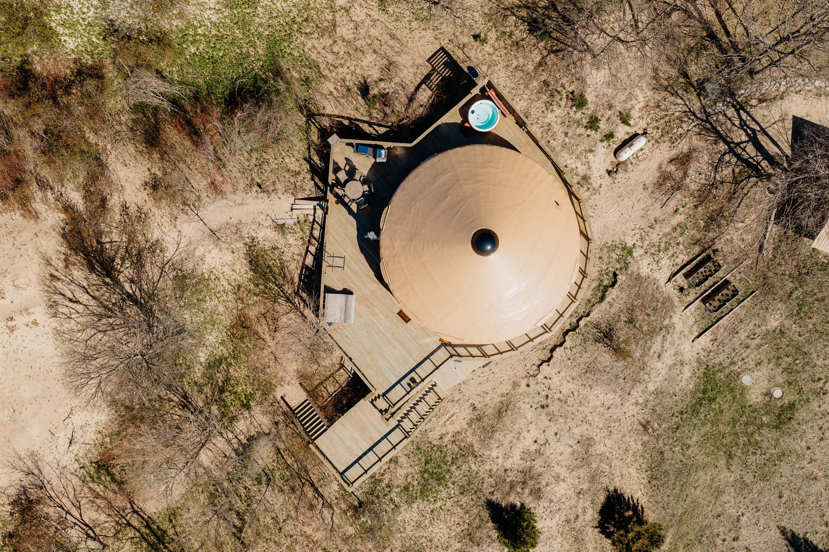 A stunning overhead view of the yurt and expansive deck space tucked into the dunes along Michigan’s breathtaking coastline.