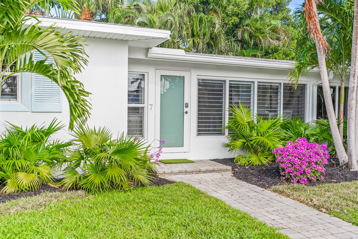 Welcome to your coastal retreat! A beautifully manicured exterior with lush tropical landscaping.