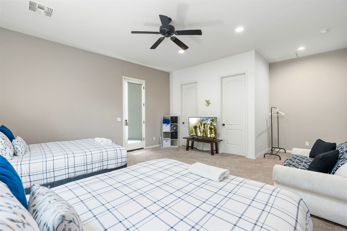 Private casita setup with two queen beds, a TV for easy entertainment, and a relaxed lounge corner—ideal for guests wanting comfort and privacy.