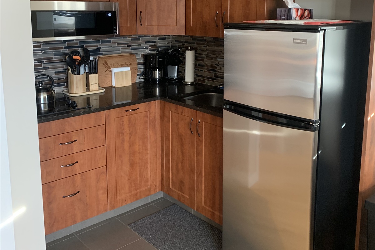 LOFT KITCHEN. TWO BURNER COOK TOP, CONVECTION MICROWAVE, FRIDGE FREEZER AS WELL AS ALL THE KITCHEN BASICS. POTS, PANS, DISHES, CONDIMENTS, SPICES AND COFFEE SUPPLIES.