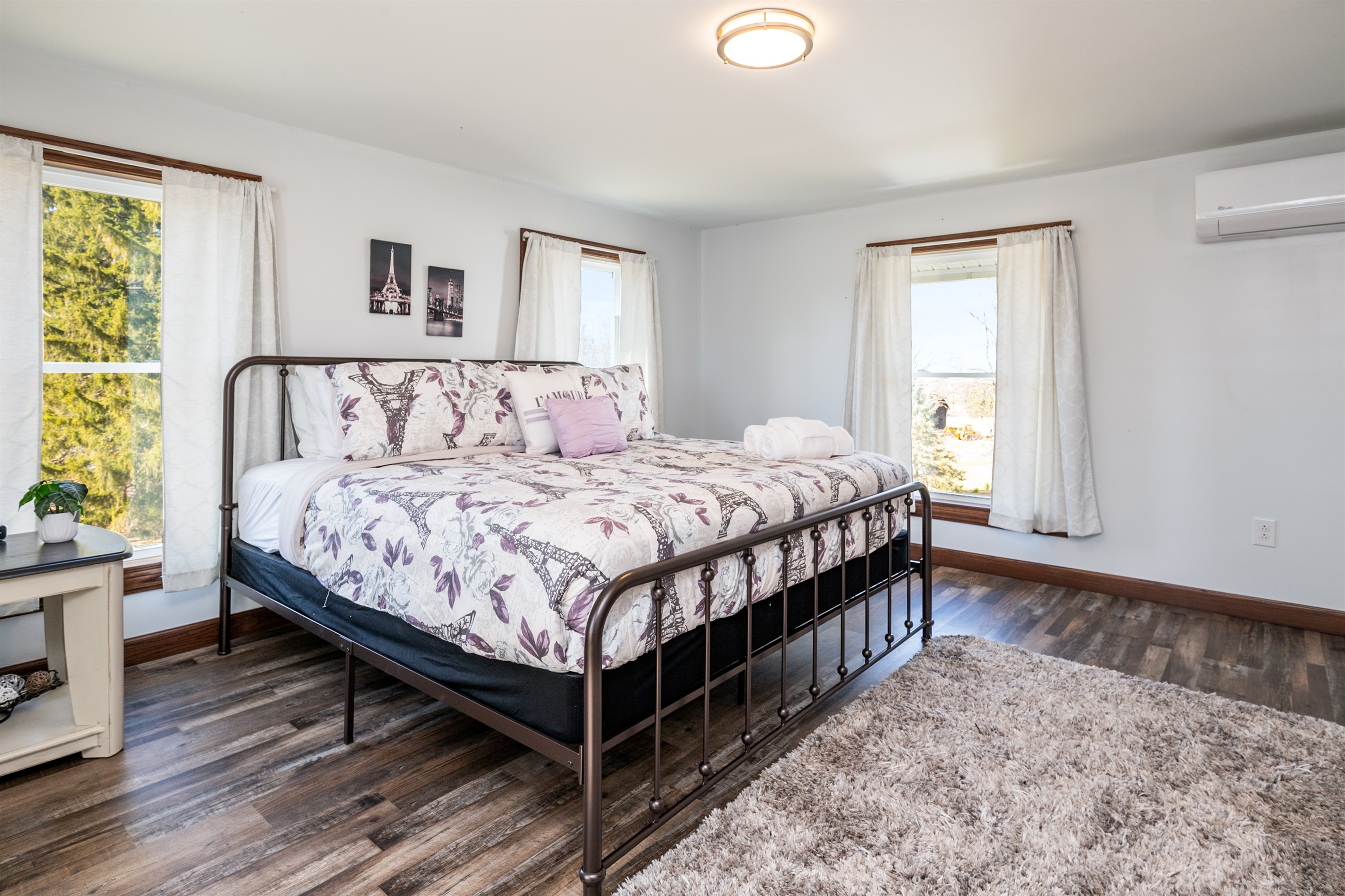 Wake up to bright morning sun and peaceful views in this inviting bedroom featuring a comfortable queen bed and crisp white linens.