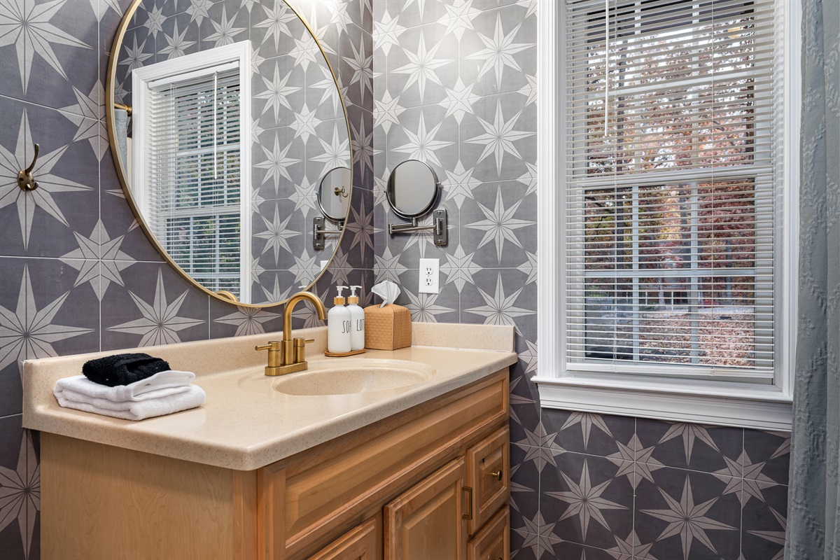 Thoughtful touches like spa-style soap, fluffy towels, and a large round mirror make freshening up easy and enjoyable.