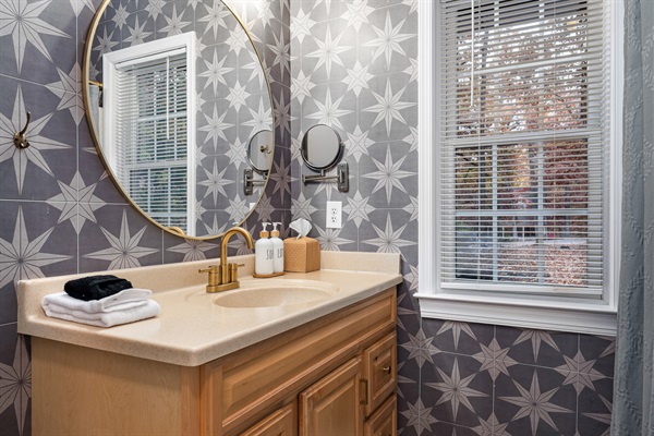 Thoughtful touches like spa-style soap, fluffy towels, and a large round mirror make freshening up easy and enjoyable.