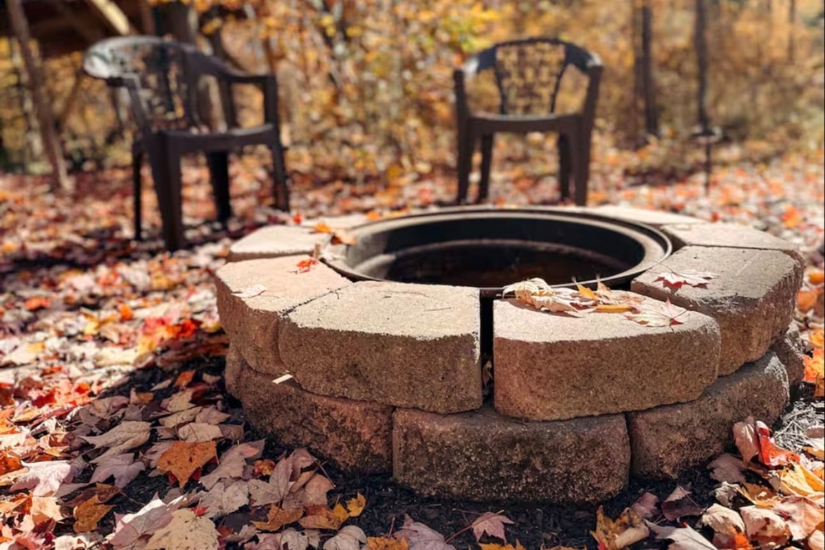 Cozy fire pit, with plastic chairs, perfect for relaxing evenings under the stars. Ample seating for everyone.