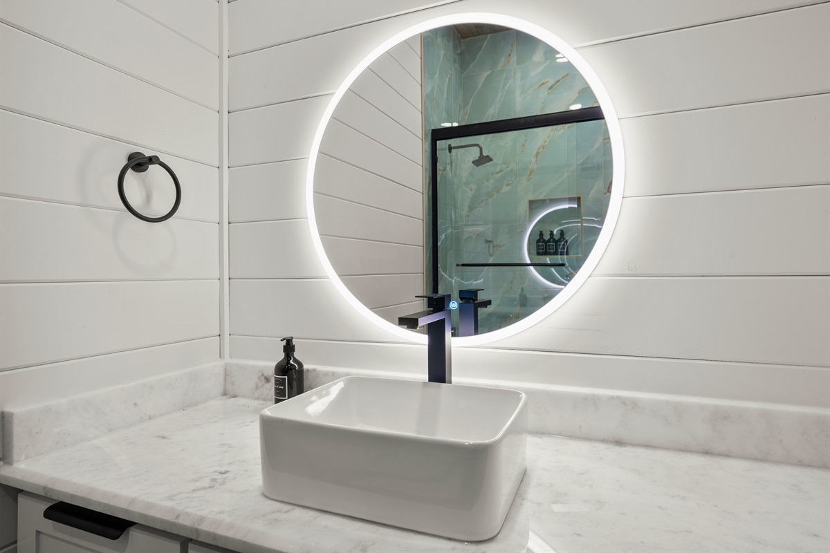 The circular mirror and simple, modern vanity design add a clean and stylish touch while still offering plenty of space for everyday use.