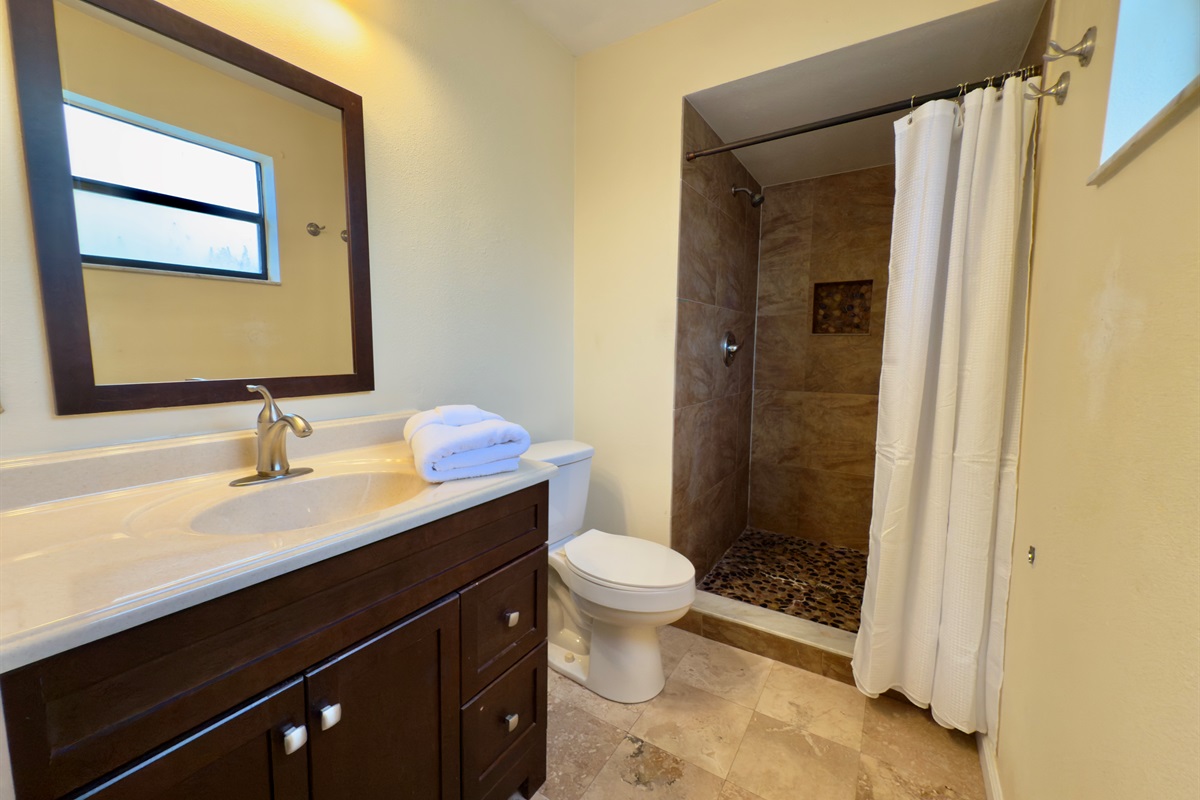This stylish and well-appointed bathroom combines functional design with warm, earthy aesthetics, creating a calming space for freshening up or winding down.