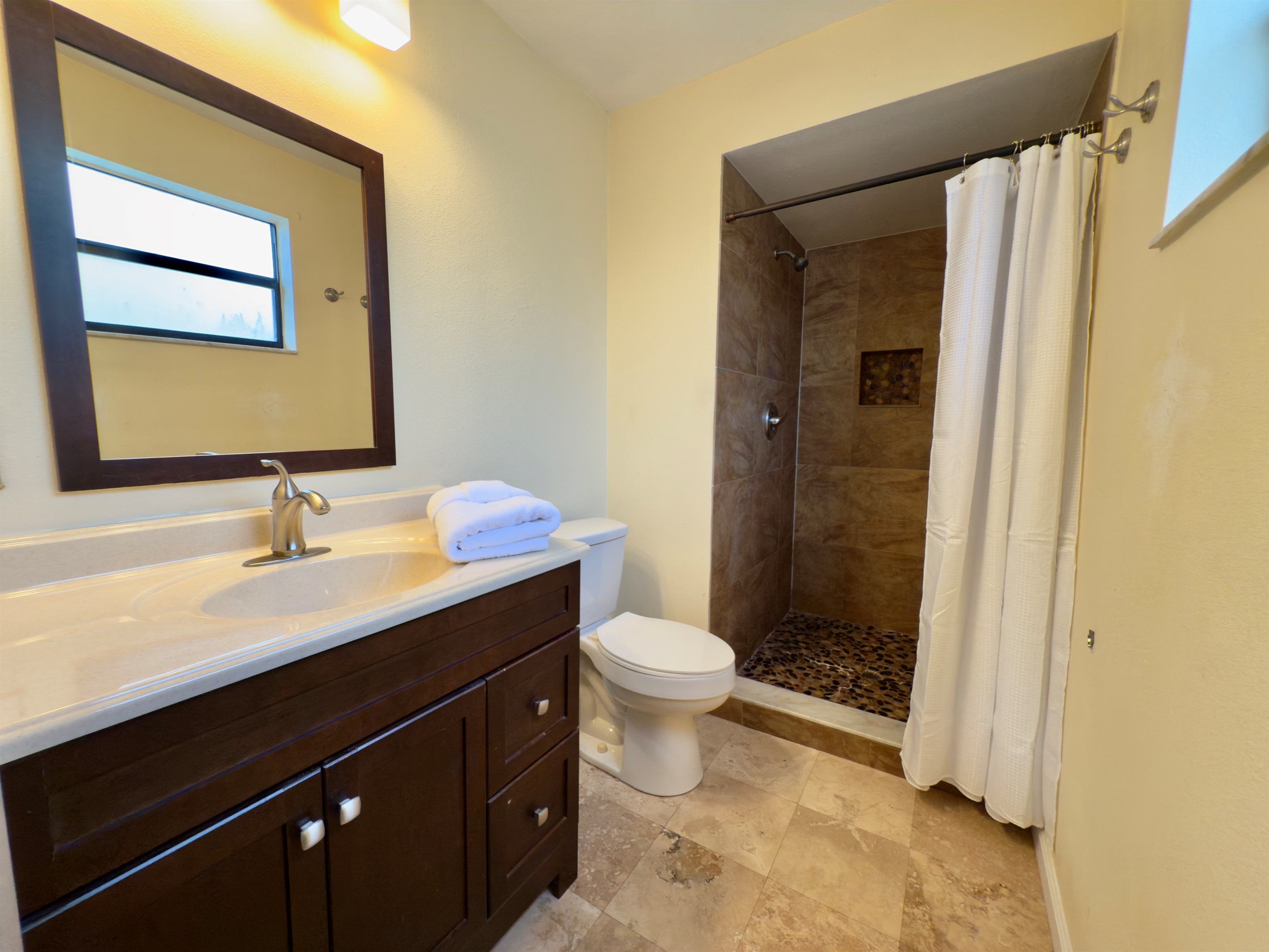 This stylish and well-appointed bathroom combines functional design with warm, earthy aesthetics, creating a calming space for freshening up or winding down.