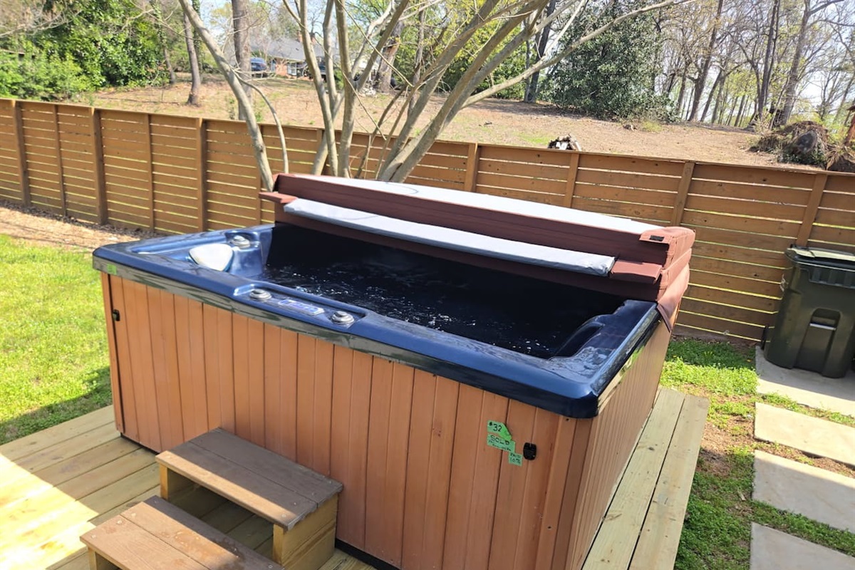 Unwind in your private outdoor hot tub, perfectly set on a spacious deck—ideal for relaxing evenings under the trees in this luxury Greenville stay.